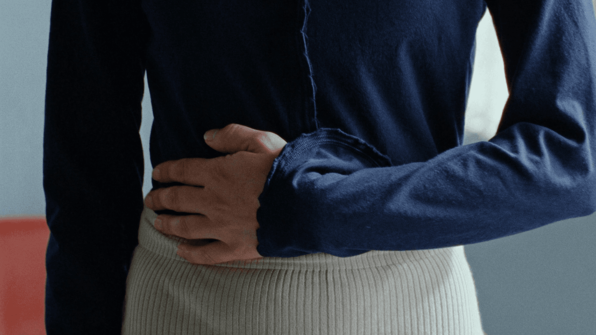A hand resting gently over the abdomen